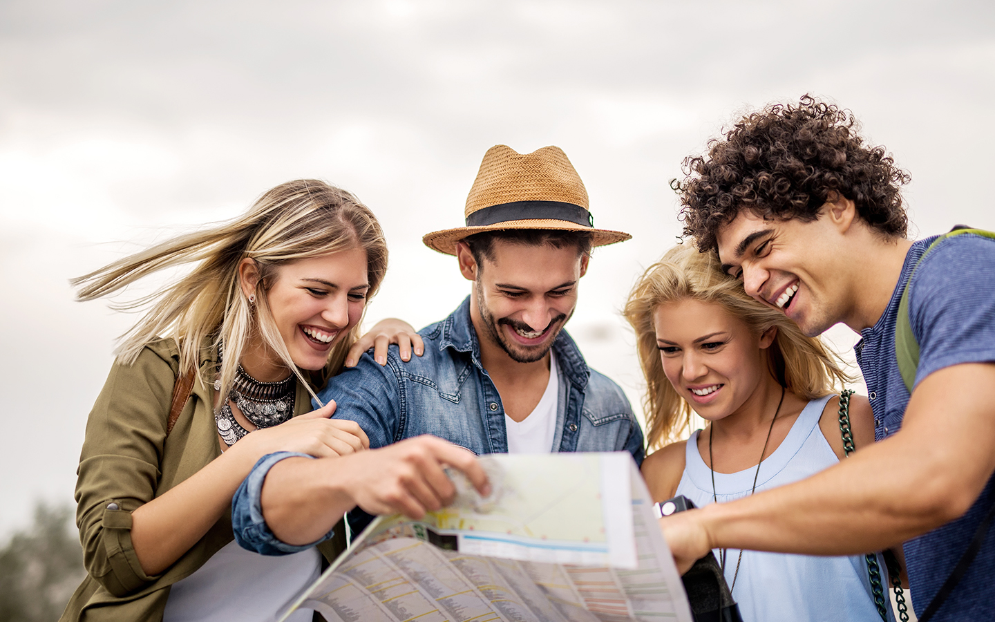 Traveling friends examine a map and smile